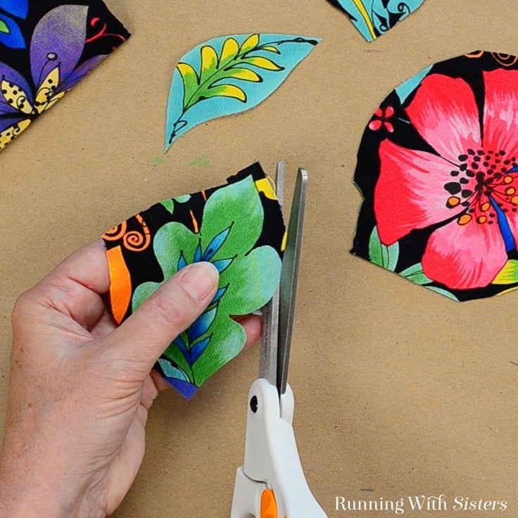 Cutting out floral fabric to put on a birdhouse