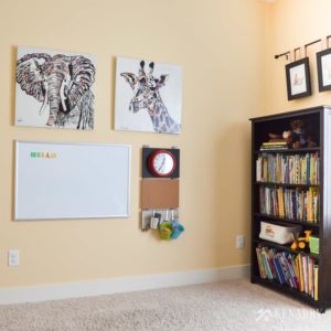 Hang a marker board or dry erase board and other playroom wall decor at eye level for kids so they can use, enjoy and learn from it. This gallery wall is part of a colorful playroom for children.