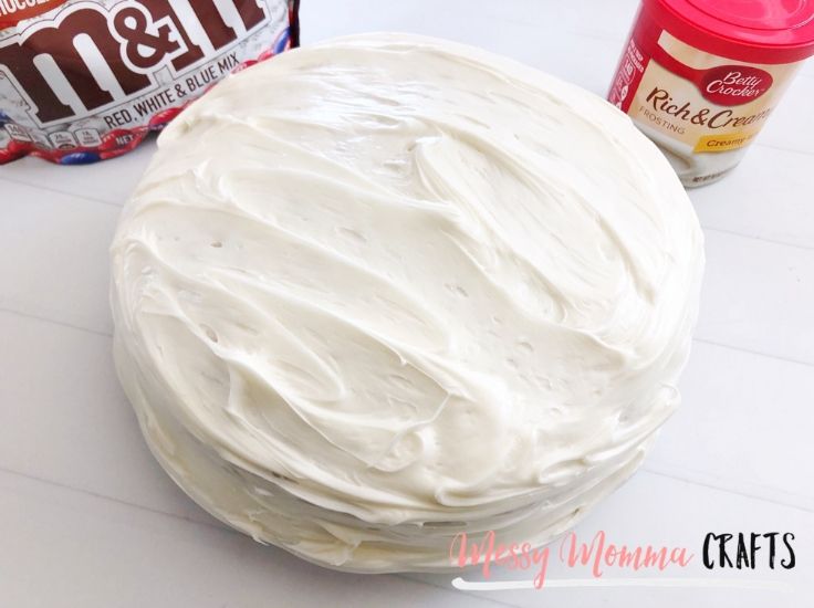 A round cake completely frosted with vanilla frosting. 