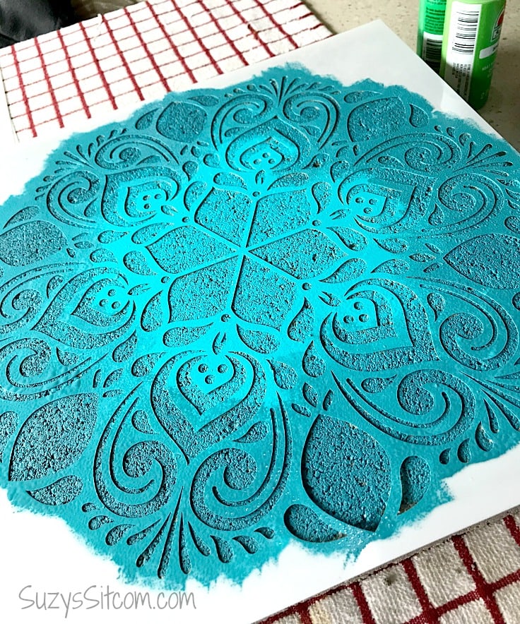 A stepping stone with a stencil painted light blue