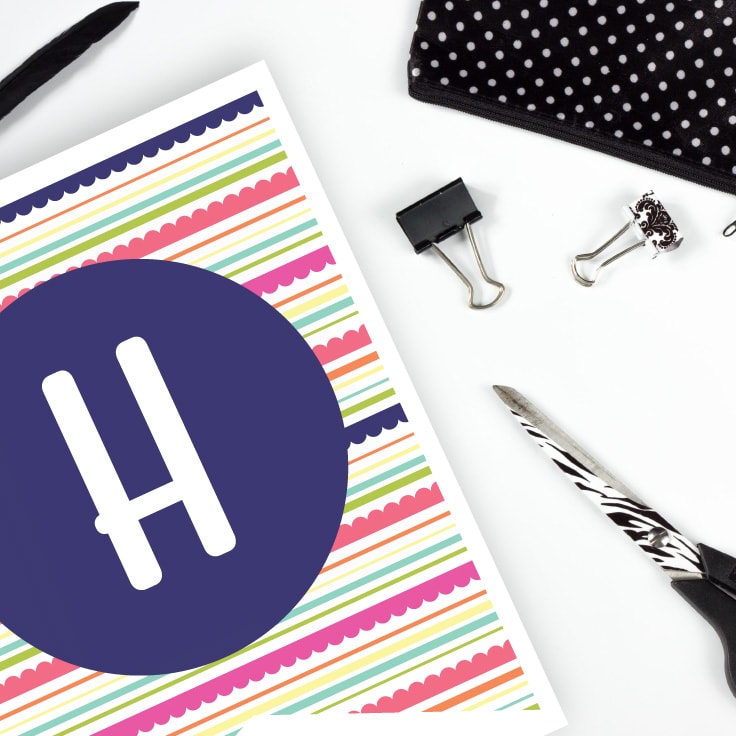 Letter H printable banner on desk with scissors and desk accessories.