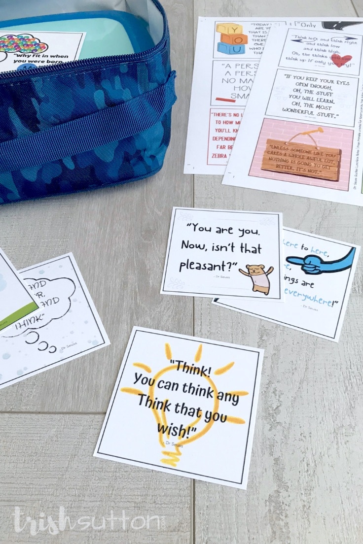Square notes with Dr. Seuss quotes laying on a wood background next to a child's open lunchbox.