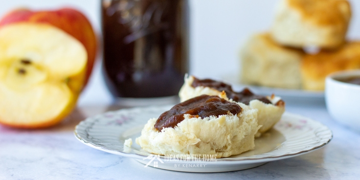 Easy Apple Butter, a close-up of homemade apple butter spread on top of a delicious biscuit
