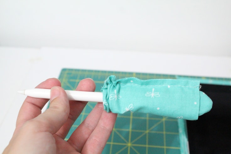 blue fabric partially covering an Apple Pencil