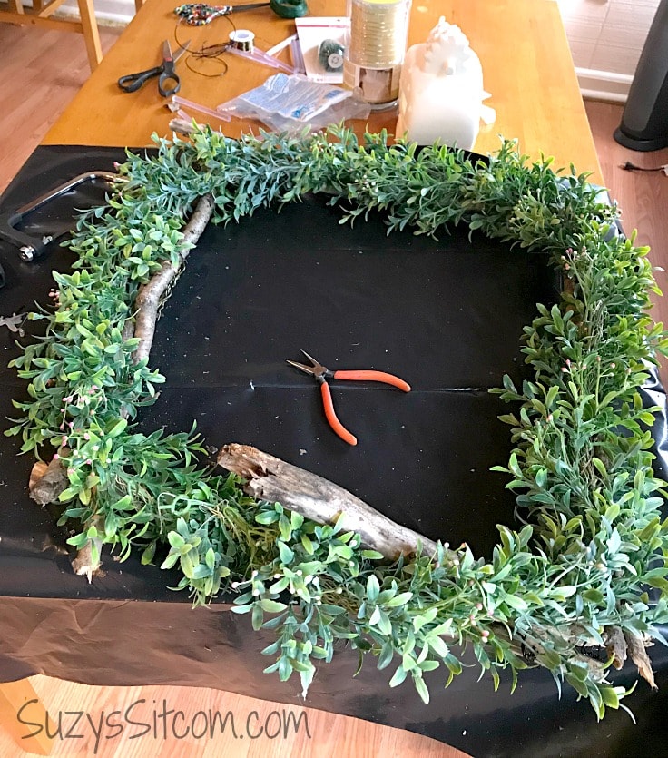 Adding greenery to the rustic wreath