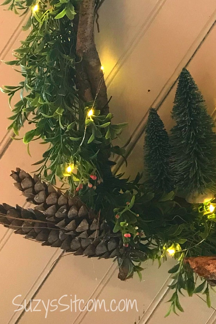 Pinecones and twinkle lights around the rustic wreath