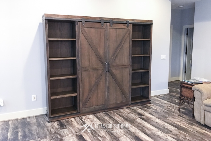 A television can be hidden behind sliding barn wood doors on this farmhouse entertainment center.