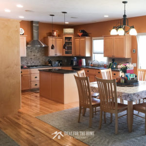 Orange kitchen with natural maple cabinets and hickory floor