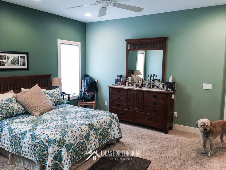 Sage green master bedroom with dark green accent wall behind a queen sized mission style bed - home makeover ideas