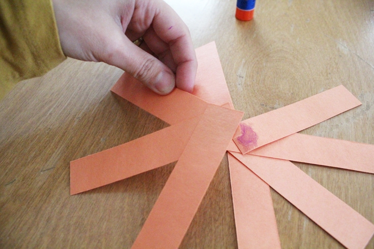 orange paper strips glued together in a starburst