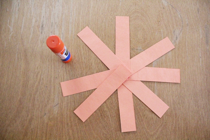 8 strips of orange paper fanned out in a starburst