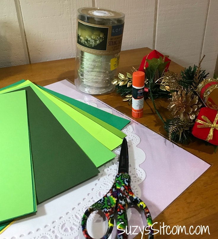 The supplies you need to create a holiday tree from paper - green cardstock, glue and scissors 