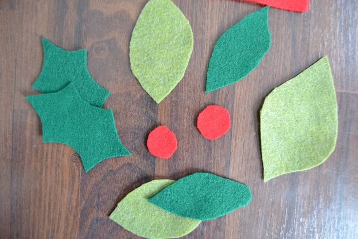 Step 1 of how to make a Christmas garland from felt- cutting out the leaves and berries from felt