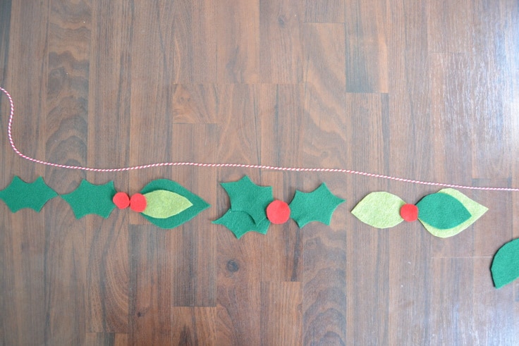 the pieces of felt leaves and berries lined up to plan out the garland
