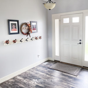 Entry way with laminate wood floors and a farmhouse style coat rack in a home