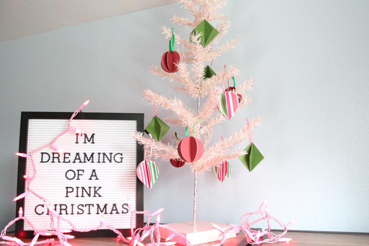 decorated pink mini Christmas tree beside a letterboard that reads 