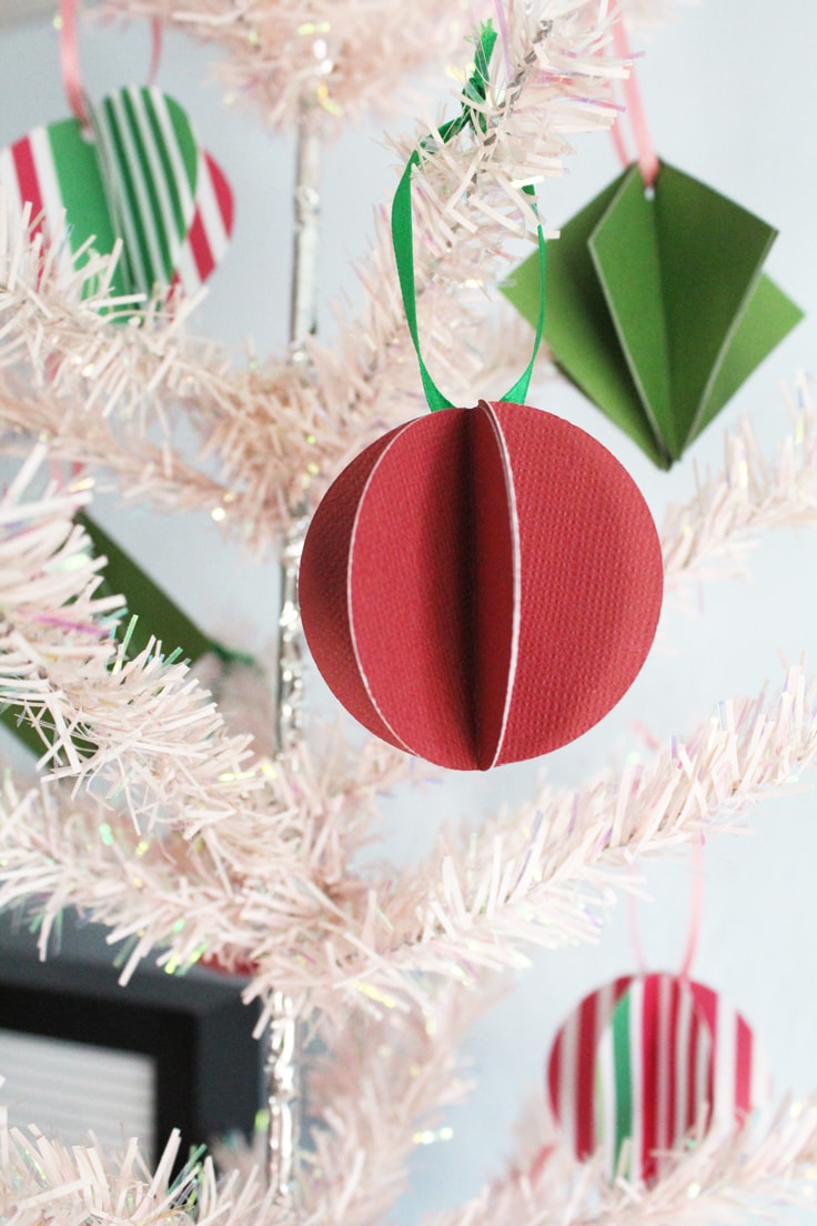 closeup of a red circle ornament on a pink tree with other ornaments