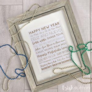 Framed New Year printable with beads on a wood background.
