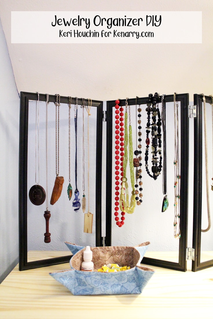 jewelry organizer made from black photo frames with necklaces hanging from the top