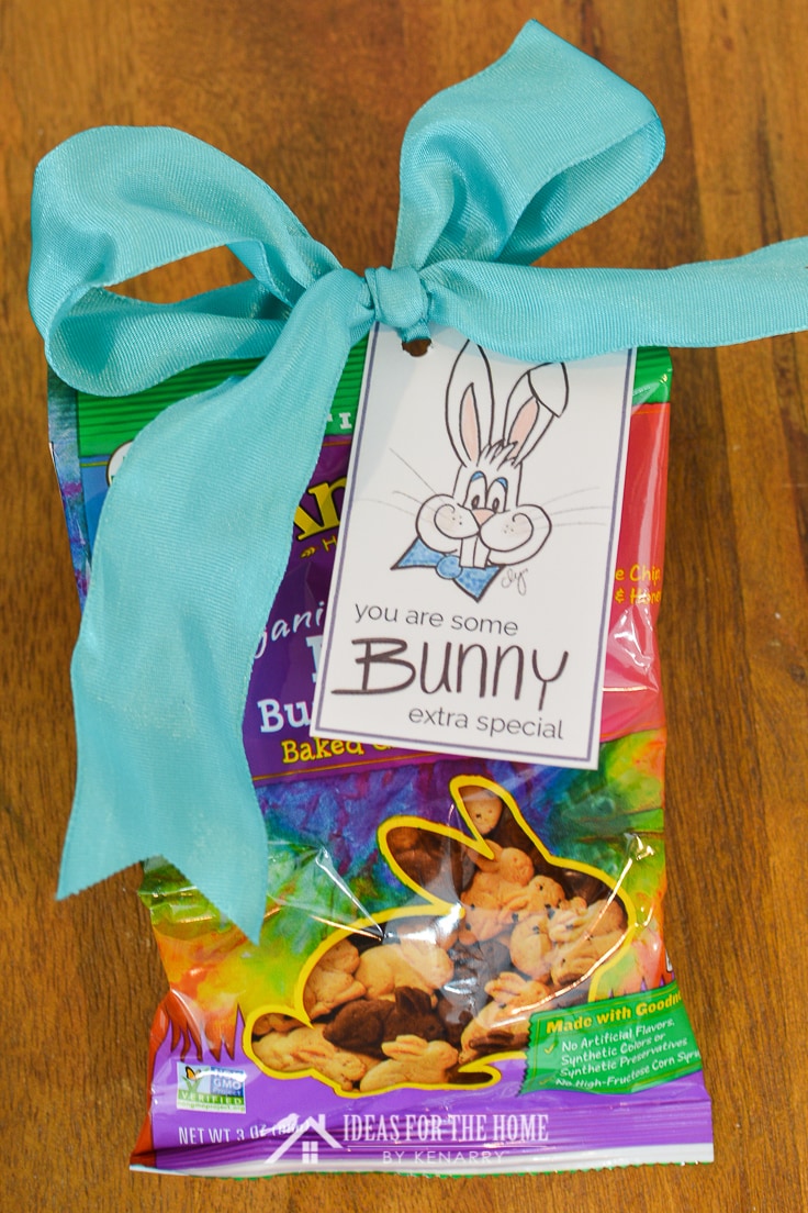 A Easter bunny on a free printable gift tag attached to a bag of graham crackers shaped like rabbits. On the Easter gift tag, it says 
