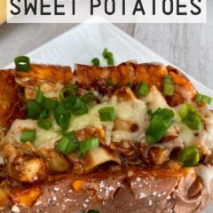 Baked sweet potato stuffed with chicken topped with cheese & green onions on a white plate.