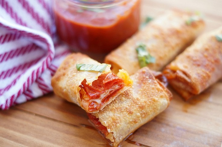 a pizza egg roll split in half showing melted pepperoni and cheese 