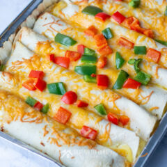 Breakfast enchiladas topped with red and green peppers for Christmas brunch