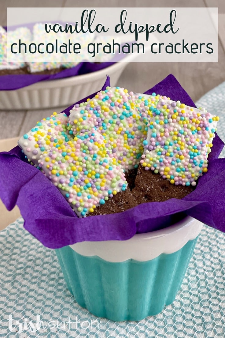 Vanilla Dipped Chocolate Graham Crackers covered in sprinkles on a purple napkin.