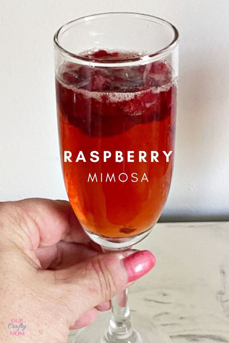 Raspberry mimosa glass with floating raspberries