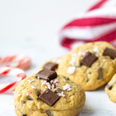 Close up of a chocolate chunk cookie topped with crushed peppermint candy canes