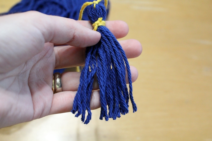 hand holding a blue tassel and separating the ends