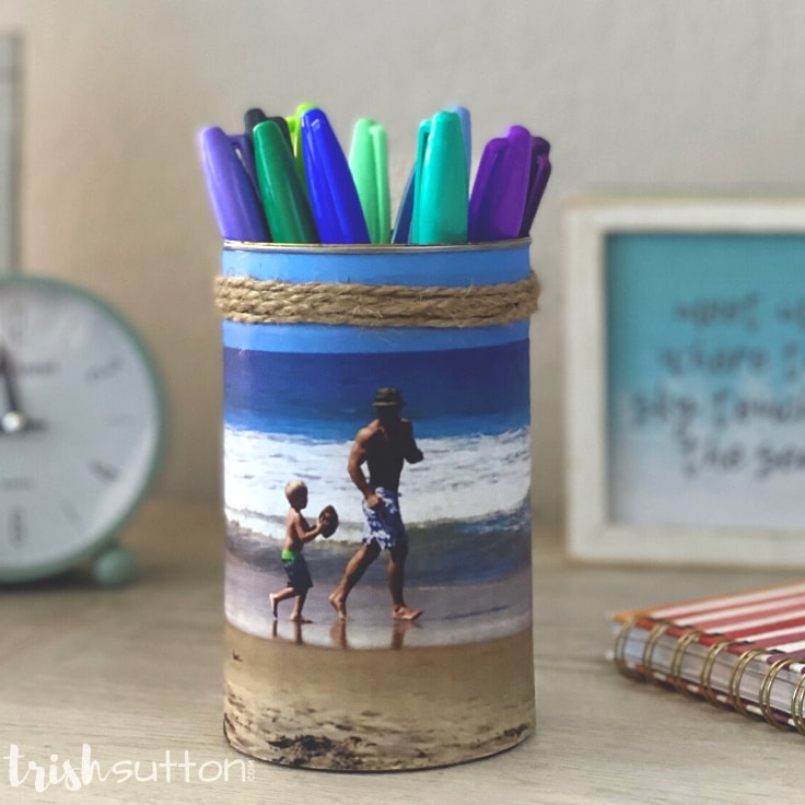 A desk with a DIY photo caddy on it; caddy is filled with colorful sharpies.