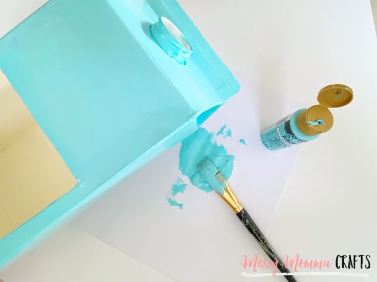Use any craft paint and a paint brush to paint the outside of your milk carton. Let dry, paint a second coat and let dry. Then you can paint a fun pattern like flowers and let dry.