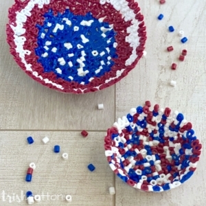 two bead bowls on a wood surface with scattered red, white & blue perler beads