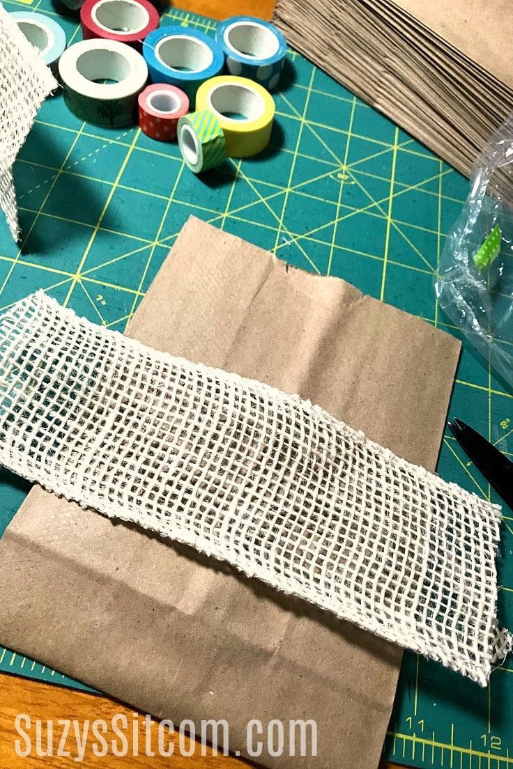 Adding burlap ribbon to the paper bag