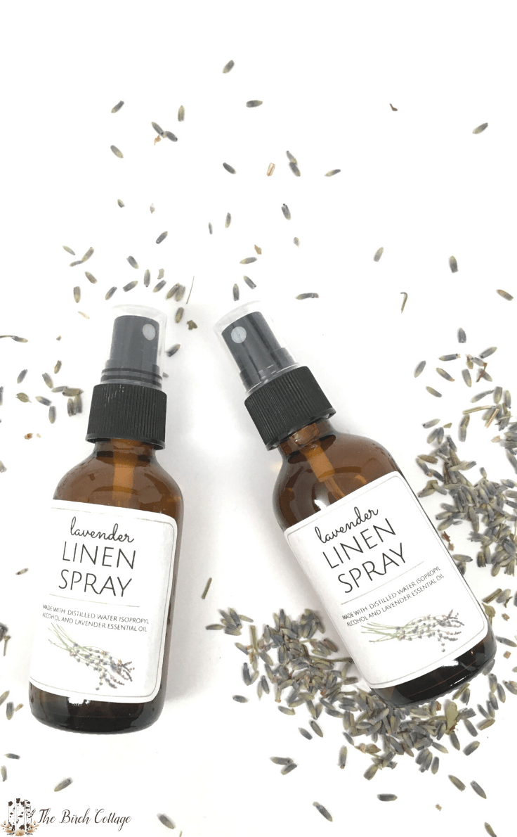 two spray bottles of lavender linen spray, bottle of lavender essential oil and lavender buds