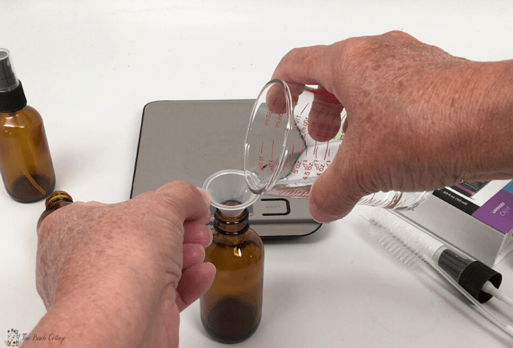 measuring isopropyl into glass amber bottle