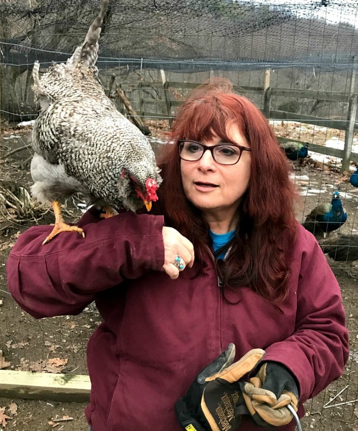 A woman with a chicken on her shoulder 
