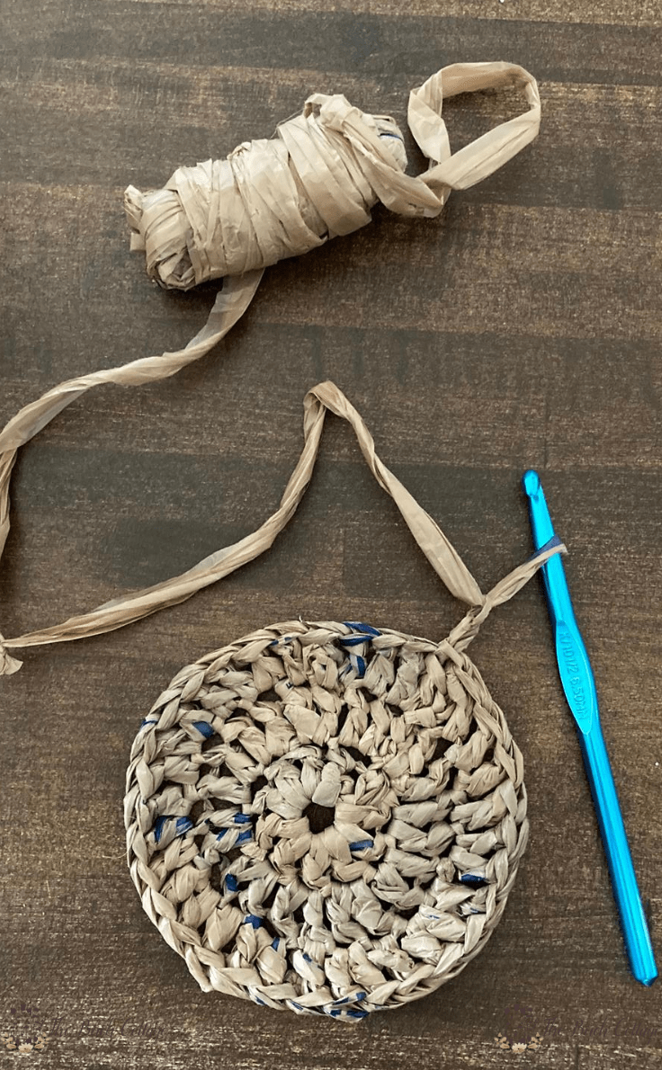 ball of plarn, crochet hook and crochet coaster