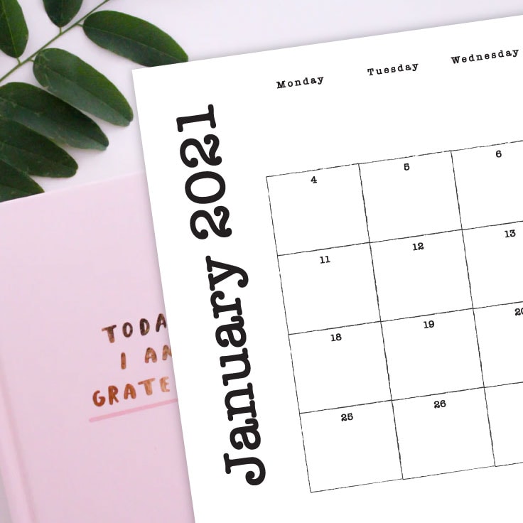 Preview of January 2021 monthly calendar on desk with journals and greenery.