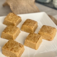 A white plate filled with squares of pumpkin fudge.