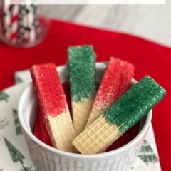 Red & green sprinkle covered dipped sugar wafer cookies in a white bowl.