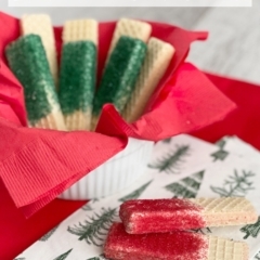 Red sprinkled sugar wafer cookies with green sprinkled cookies in the background.