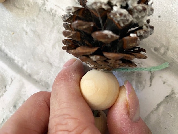 bead glued to pine cone