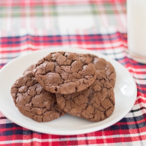 A plate full of chocolate cookies made out of a simple brownie mix on a plaid place mat.