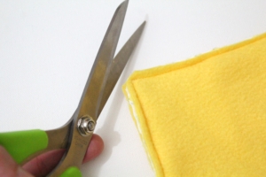scissors cutting the corner tips off of a sewn pillow cover