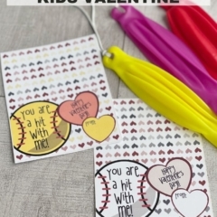 Kids valentine note cards with punch balloons on a wood background.