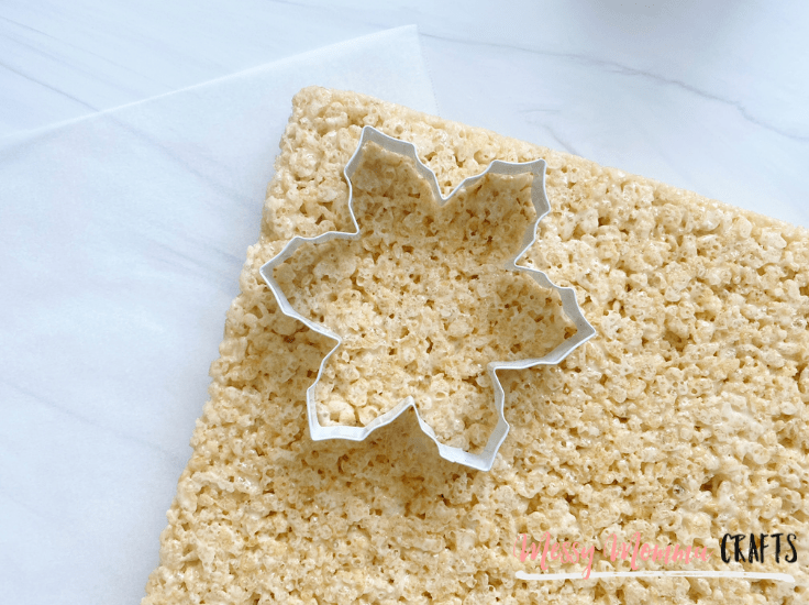 a snowflake-shaped cookie cutter sitting on top of a bar of Rice Krispie treats