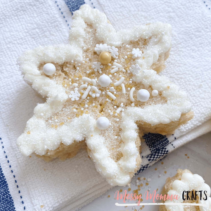white snowflake shaped Rice Krispies treat decorated with frosting and sprinkles