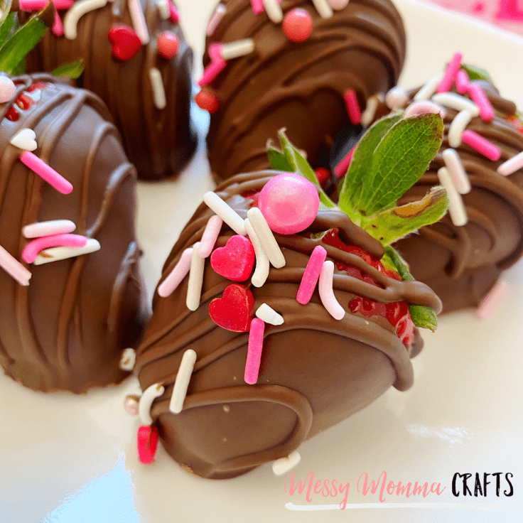 Homemade chocolate covered strawberries with red and pink sprinkles.